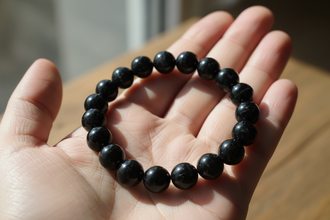 cretate a black tourmaline braclket photo holding in palm authentic and real not ai generated